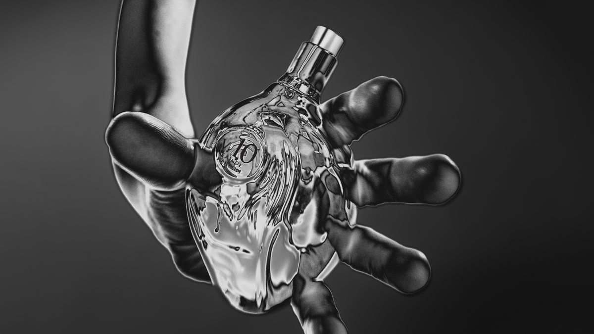A hand reaching out, holding the silver V.10 Frisson bottle